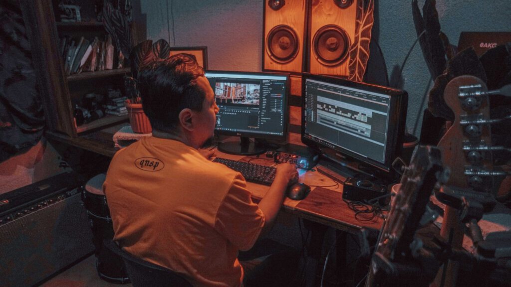 A man sitting at a desk in front of two monitors.