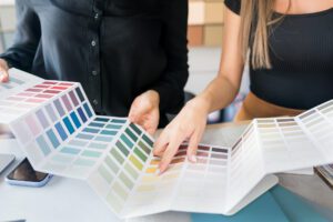 Two women looking at color samples on a table.